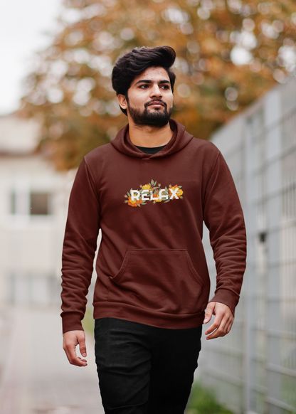 Man wearing a brown hoodie with 'Relax' text outdoors