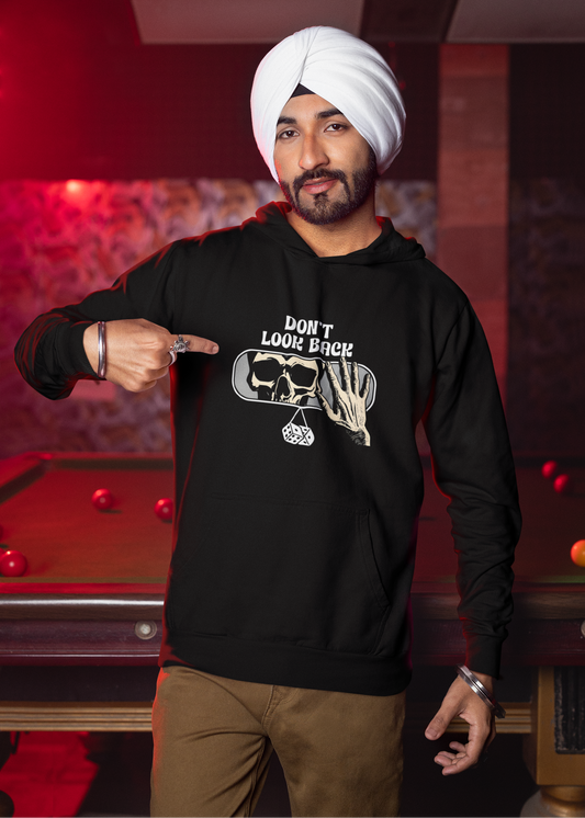 Man wearing a black hoodie with a graphic design, standing in a room with a pool table.